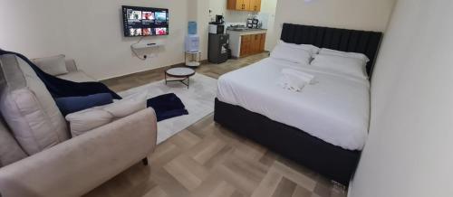 een slaapkamer met een bed en een bank bij Studios,1,2 and 3bedrooms in Nakuru town with a lake view. in Nakuru
