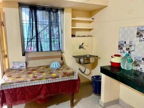 ein kleines Zimmer mit einem Tisch und einem Fenster in der Unterkunft Divine view - 1 bhk AC - Swarna Bhavan in Puri