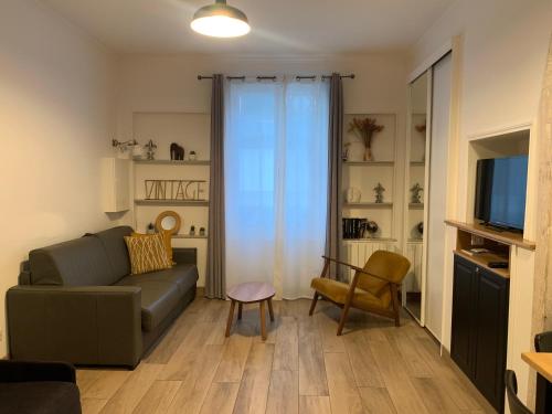 un salon avec un canapé et une télévision dans l'établissement Trouville Plage Casino, à Trouville-sur-Mer