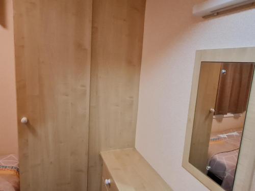 Cette chambre comprend une armoire en bois et un miroir. dans l'établissement BLUE BIRD HOLIDAY HOME, à Durham
