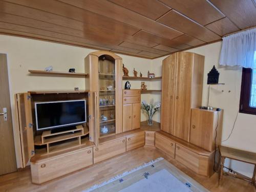 a living room with a flat screen tv and wooden cabinets at Hell und gemütlich, ca. 60qm. in Osnabrück