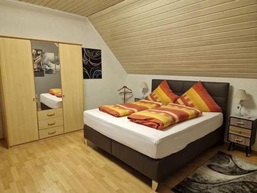 ein Schlafzimmer mit einem Bett mit Kissen und einem Spiegel in der Unterkunft Hell und gemütlich, ca. 60qm. in Osnabrück