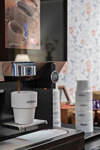 a coffee maker with a cup on a counter at First Camp Moraparken Hotel in Mora