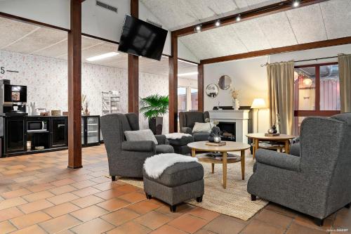 - un salon avec plusieurs chaises et une télévision dans l'établissement First Camp Moraparken Hotel, à Mora