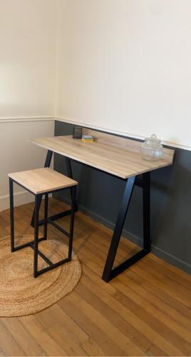 - un bureau en bois avec un tabouret dans l'établissement Le quai des marins, à Châteauroux