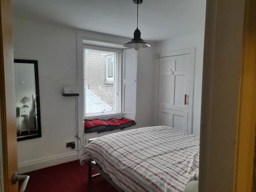 1 dormitorio con cama y ventana en Charming Eyemouth apartment close the beach en Eyemouth