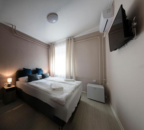1 dormitorio con 1 cama grande y TV en Noel Vendégház, en Szeged