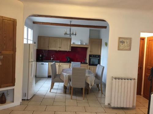 une cuisine avec une table et des chaises dans une pièce dans l'établissement La maison de pepe a rougiers, à Rougiers
