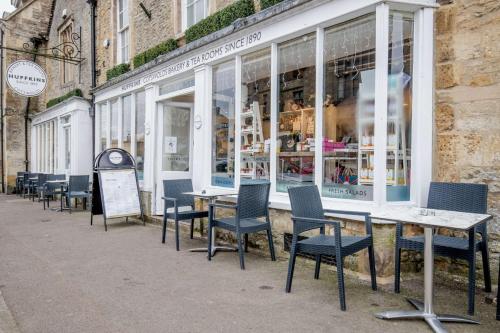a row of tables and chairs in front of a store at Church View Apartment in Stow on the Wold