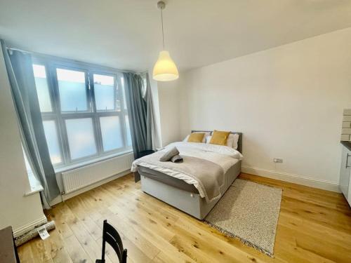 a bedroom with a bed and a large window at SE4, Self contained studio flat. in London