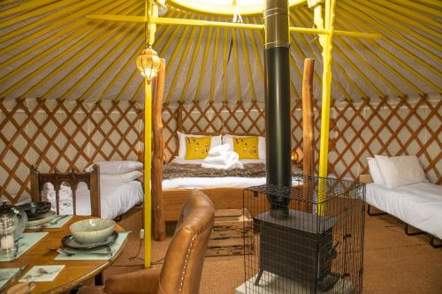 Habitación con cama y mesa en una yurta en Cherish Glamping en Askrigg
