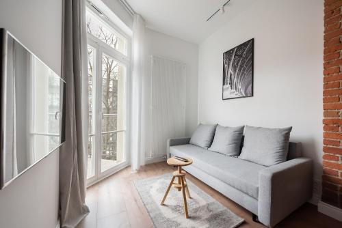 a living room with a couch and a window at East Warsaw Modern Apartment in Warsaw