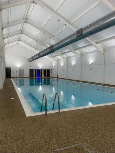 a large swimming pool in a large building at Hotdog House Filey Detached Pet Friendly Eco-House in Hunmanby