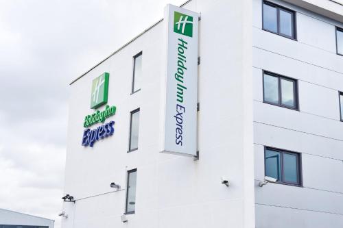 a white building with signs on the side of it at Holiday Inn Express Manchester Airport by IHG in Hale