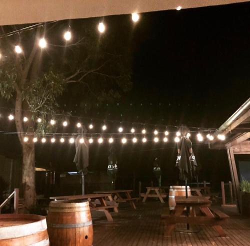 a group of picnic tables under a string of lights at Isla Villa, Cowes, Phillip Island. in Cowes