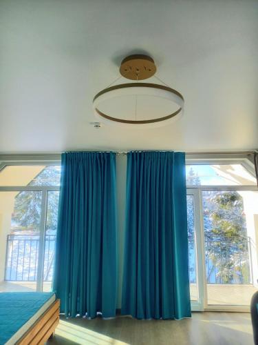 a bedroom with blue curtains and a chandelier at Отель MONBLAN in Yablunytsya