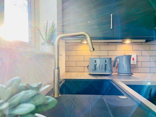 a kitchen counter with a sink and a faucet at Lovely family house, great links M62, edge of Leeds in Liversedge