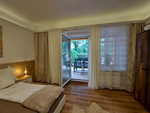 um quarto com uma cama e uma porta de vidro deslizante em AusZeit Steiraland 3 mit überdachter Terasse privatem Garten und gratis Parkplatz em Leoben