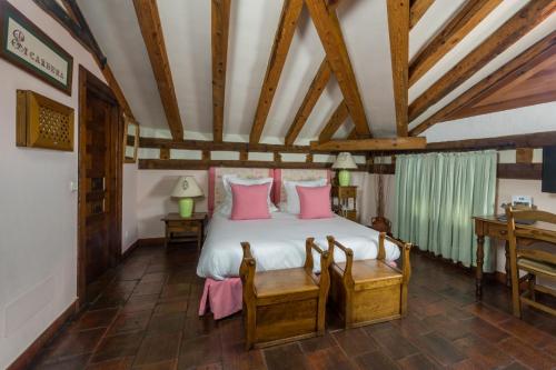 a bedroom with a large bed with pink pillows at Posada Real Mingaseda in Navafría