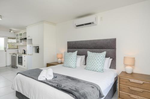 1 dormitorio con 1 cama blanca grande con almohadas azules en San Lameer Villa 2519 - Bachelor Studio - 2 pax - San Lameer Rental Agency, en Southbroom