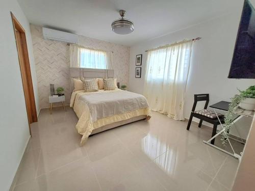 een slaapkamer met een bed en een tafel. bij Getaway To Cozy Home 4 Br, 35 B in Santo Domingo