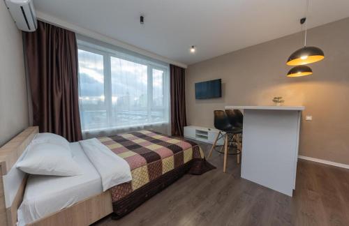 ein Hotelzimmer mit einem Bett und einem Fenster in der Unterkunft Апартаменты метро Вырлица in Kiew