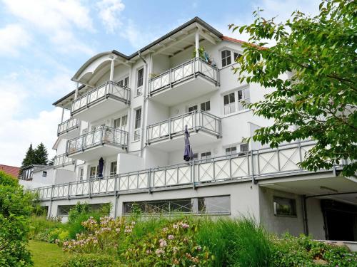 ラウターバッハにあるVilla Vilmblick - Wohnung 05 mit Terrasse und Boddenblickのバルコニーと木々のある白い建物