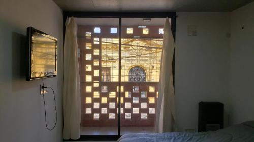 1 dormitorio con puerta corredera de cristal y ventana en Monoambiente temporario Rosario barrio Pichincha en Rosario