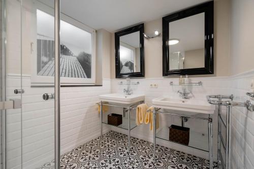 a bathroom with two sinks and two mirrors at Ferienhaus Ekke Nekkeppen2 in Westerland (Sylt)