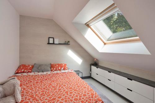 een slaapkamer op zolder met een bed en een raam bij Familie Vakantiehuisje F108 - 4p - Hengelhoef - Houthalen-Helchteren in Aan de Wolfsberg