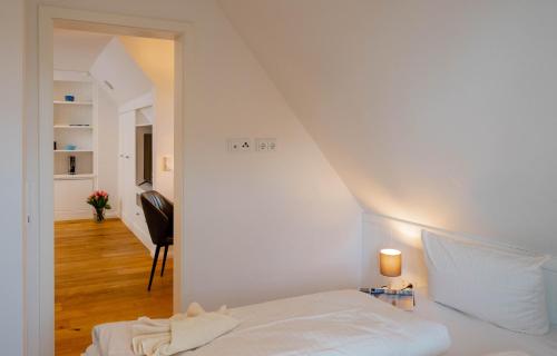 ein weißes Schlafzimmer mit einem Bett und einem Flur in der Unterkunft Ferienwohnung Käthe in Wenningstedt-Braderup