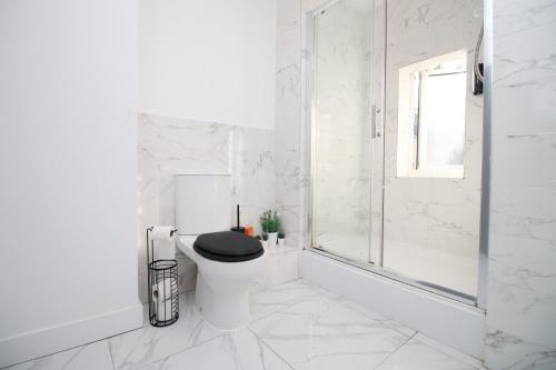 uma casa de banho branca com um WC com um assento preto em Executive Style 2 Bed Flat in Bridgend F2 em Bridgend