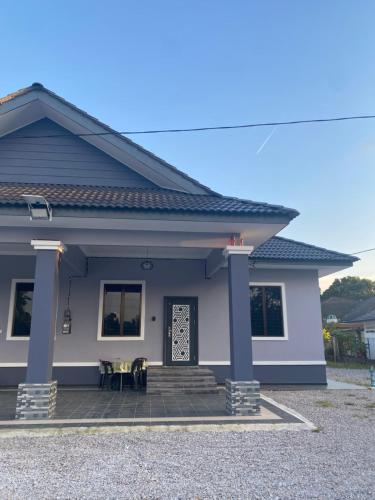 a small house with a patio in front of it at The Family Guesthouse in Kota Bharu