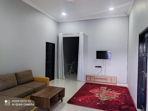 ein Wohnzimmer mit einem Sofa und einem roten Teppich in der Unterkunft The Family Guesthouse in Kota Bharu