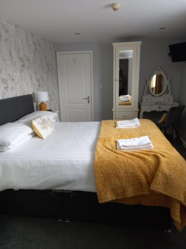 a bedroom with a large white bed with towels on it at Crossroads House in Carlisle