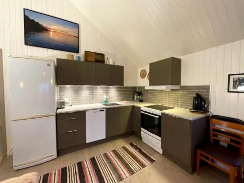 a kitchen with a refrigerator and a stove top oven at Ocean View Tind Lofoten in Moskenes