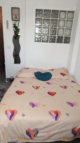 a bed with a comforter on it in a bedroom at à 30 minutes de tour Eiffel in Montreuil