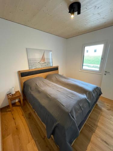 a bedroom with a large bed in a room with a window at Apartment Relax - Stubenbergsee in Stubenberg