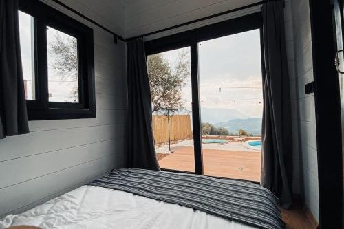 a bedroom with a bed and a window with a view at Olive Garden Tiny House in Kumluca
