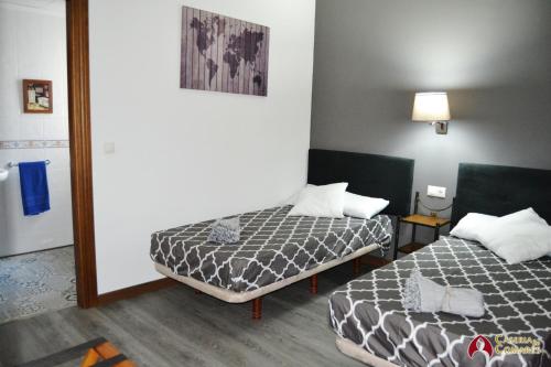 Habitación pequeña con 2 camas y espejo. en Caseria de Comares 201 en Granada