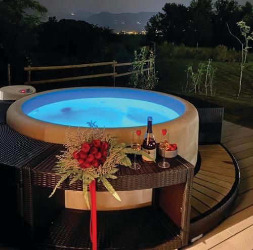 uma banheira de hidromassagem com uma mesa e uma garrafa de vinho em Natur Air Suite em Ghiaie