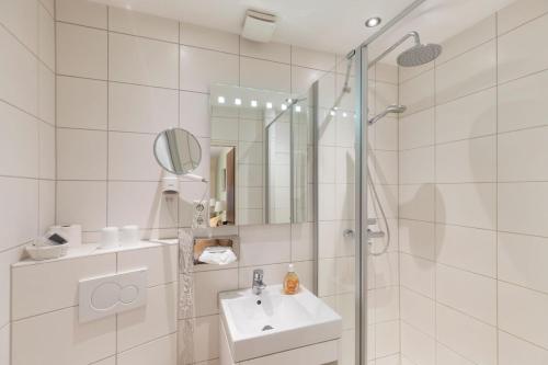 ヴィーツェンドルフにあるBrammers Landhotel Zum Wietzetalの白いバスルーム(シンク、シャワー付)