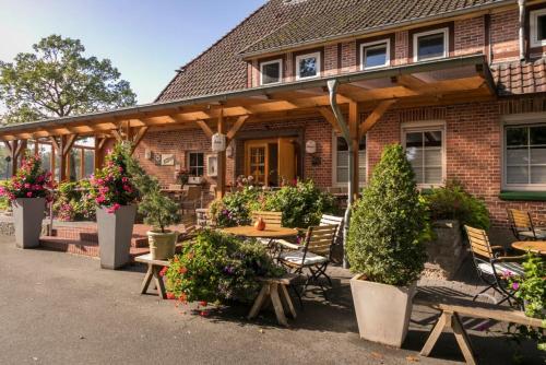 a brick house with a wooden pergola at Brammers Landhotel Zum Wietzetal in Wietzendorf