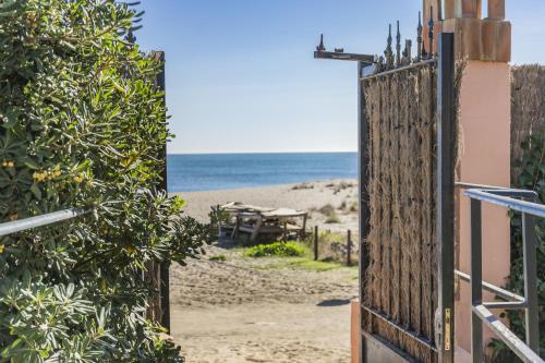 a gate to the beach with the ocean in the background at Don Juan Beach Resort in Estepona