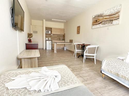 a room with two beds and a dining room at Antonis G. Hotel Apartments in Voroklini