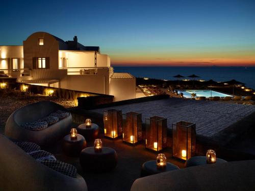 un patio panoramico con candele e divani di notte di Absolute Paradise Santorini ad Akrotírion