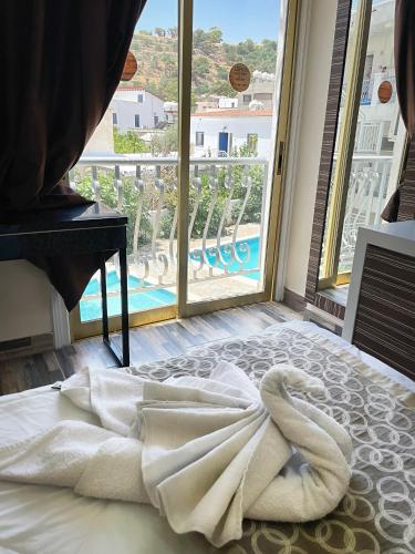 a bed with a towel on it in front of a window at Antonis G. Hotel Apartments in Voroklini