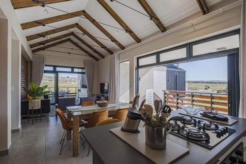 a kitchen and dining room with a view of the city at Kabeljauws Beach Apartments in Jeffreys Bay