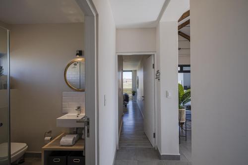 a bathroom with a sink and a mirror at Kabeljauws Beach Apartments in Jeffreys Bay
