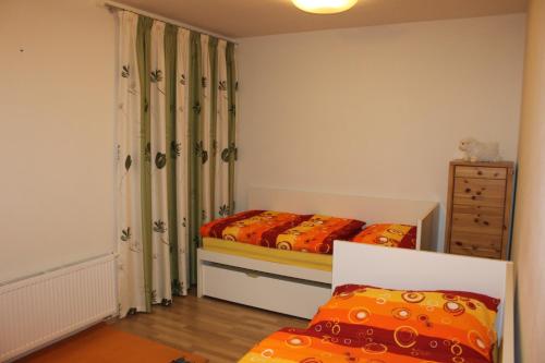 a small bedroom with two beds and a dresser at Apartments Klinovec in Loučná pod Klínovcem